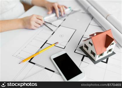 business, architecture, building, construction and people concept - close up of smartphone and living house layout over architect hands with compass measuring blueprint