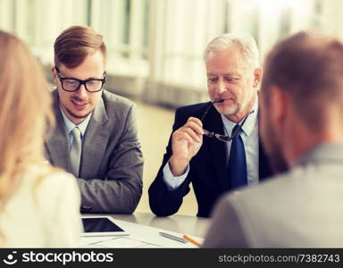 business, architecture, construction, teamwork and people concept - happy group of architects with tablet pc computer discussing blueprint at office. architects with tablet pc and blueprint at office