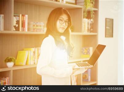 Business Asian girl leaning and using a laptop in library