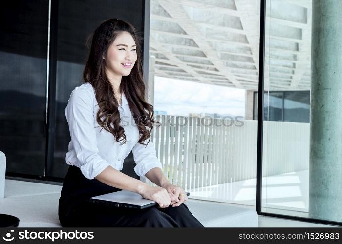 Business Asian woman sitting and smiling looking up with positive emotional,Business Startup Concept