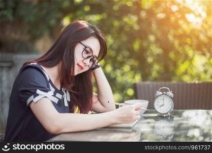 Business Asian woman working with laptop computer and clock on office outdoor.