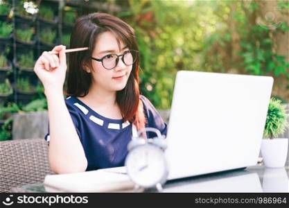 business Asian woman working with laptop computer and clock on office outdoor.