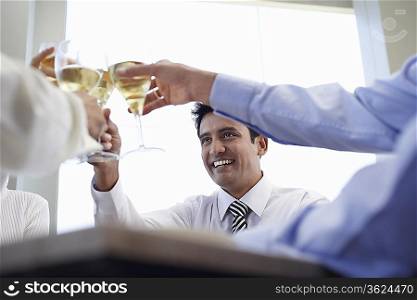 Business associates toasting with wine glasses, close-up