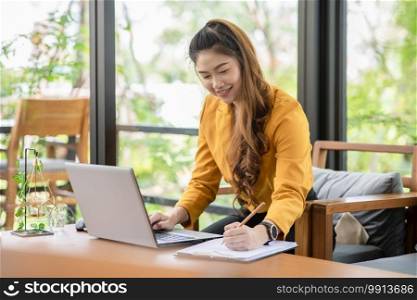 Business Attractive Asian young woman working with laptop smile and writing idea and requirement for success job outside office in coffee shop,Small Business Concept,Warm Tone