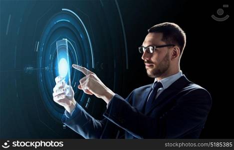 business, augmented reality and future technology concept - businessman in glasses working with transparent tablet pc computer and hologram over black background. businessman working with transparent tablet pc