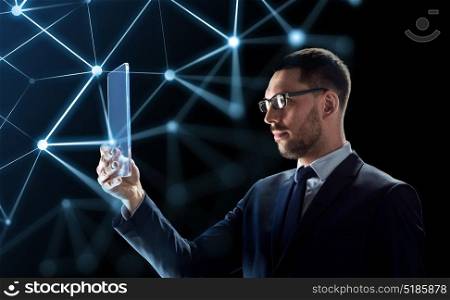 business, augmented reality and future technology concept - businessman in glasses working with transparent tablet pc computer and virtual low poly shape projection over black background. businessman working with transparent tablet pc