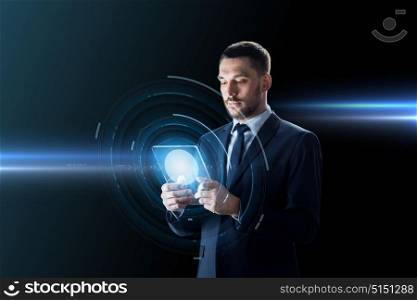 business, augmented reality and future technology concept - businessman in suit working with transparent tablet pc computer and hologram over black background. businessman working with transparent tablet pc