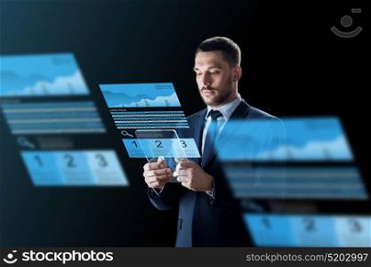 business, augmented reality and future technology concept - businessman in suit working with transparent tablet pc computer and virtual exchange charts projections over black background. businessman with tablet pc and exchange charts