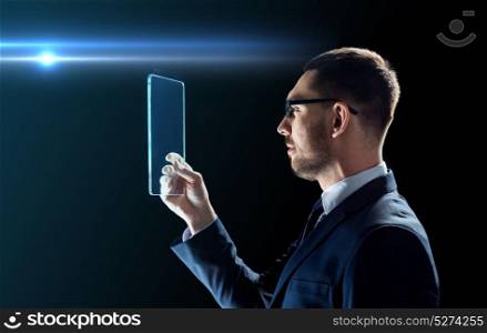 business, augmented reality and modern technology concept - businessman in glasses working with transparent tablet pc computer over black background. businessman working with transparent tablet pc