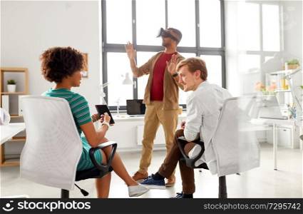 business, augmented reality and technology concept - creative team with tablet pc computer testing virtual headset or 3d glasses at office. developers with virtual reality headset at office