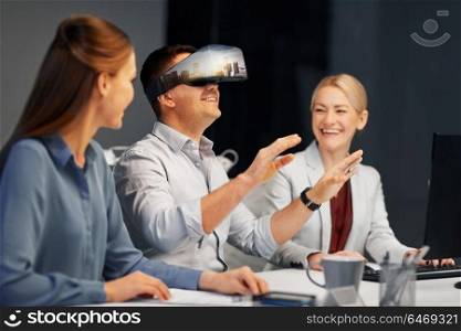 business, augmented reality and technology concept - developers with singapore city on virtual headset or 3d glasses screen working late at night office. developers with virtual reality headset at office