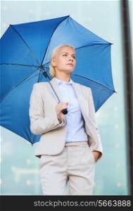business, bad weather and people and concept - young serious businesswoman with umbrella outdoors