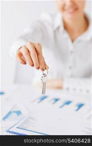 business, banking, real estate concept - woman hand holding house keys