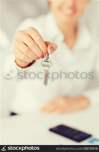 business, banking, real estate concept - woman hand holding house keys