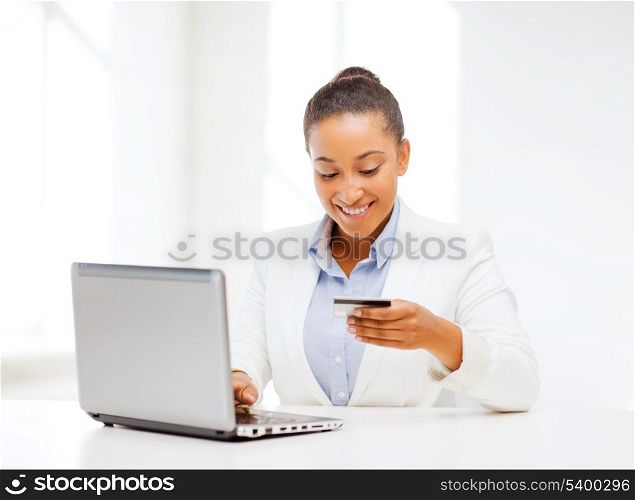 business, banking, technology, money, shopping concept - smiling businesswoman with laptop and credit card