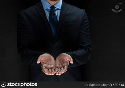 business, bankruptcy, people and crisis concept - close up of businessman in suit with empty hands over black