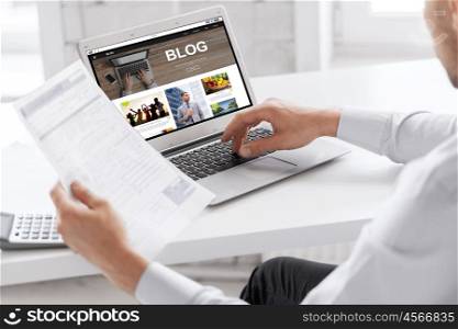 business, blogging, technology and people concept - businessman with internet blog page on laptop computer screen working at office