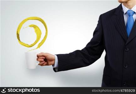Business break. Businessman holding white cup with splashes in hand