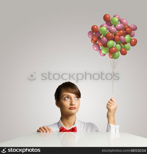 Business break. Young attractive businesswoman holding bunch of colorful balloons