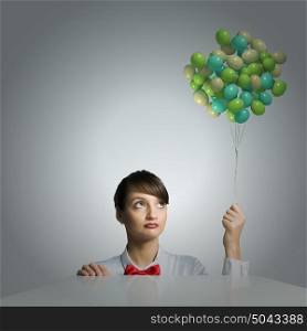 Business break. Young attractive businesswoman holding bunch of colorful balloons