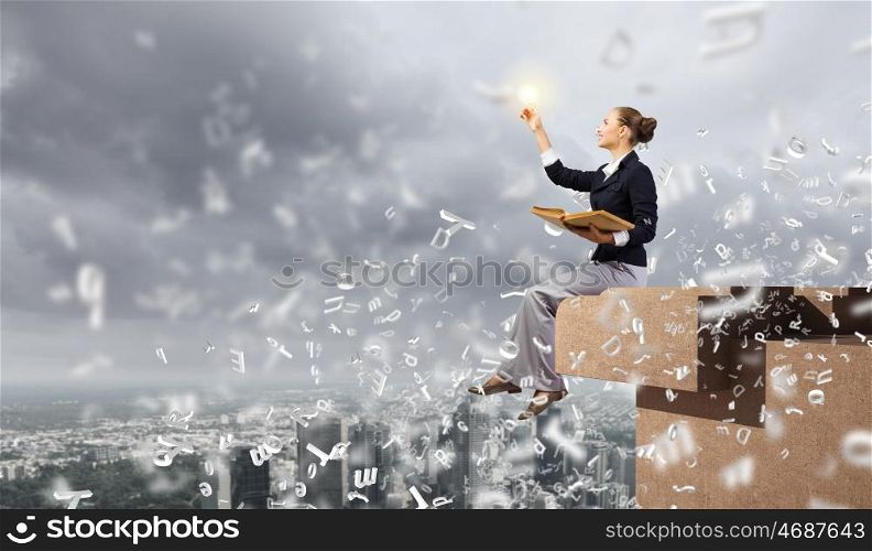 Business break. Young attractive businesswoman sitting on roof of building and reading