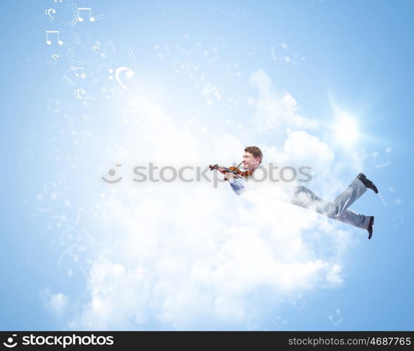 Business break. Young businessman flying high above city and playing violin