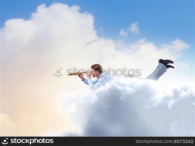 Business break. Young businessman flying in sky and lokking in spyglass