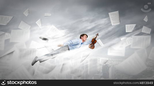 Business break. Young businessman flying in sky and playing fife