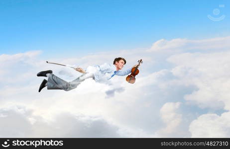 Business break. Young businessman flying in sky and playing violin