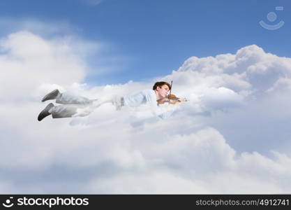 Business break. Young businessman flying in sky and playing violin