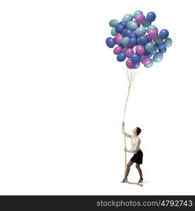 Business break. Young businesswoman pulling bunch of colorful balloons