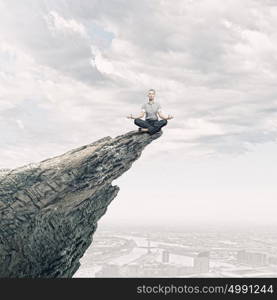 Business break. Young businesswoman sitting on top of hill and meditating