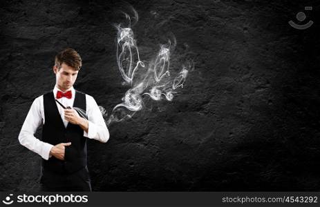 Business break. Young handsome businessman in fumes smoking pipe
