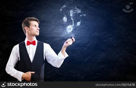 Business break. Young handsome businessman in fumes smoking pipe