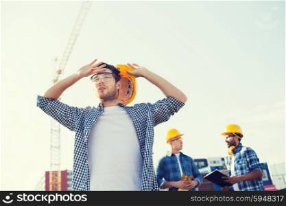 business, building, teamwork and people concept - group of builders in hardhats outdoors