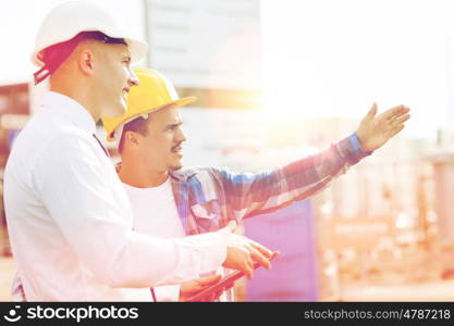 business, building, teamwork, technology and people concept - builder and architect or businessman in hardhats with tablet pc computer outdoors