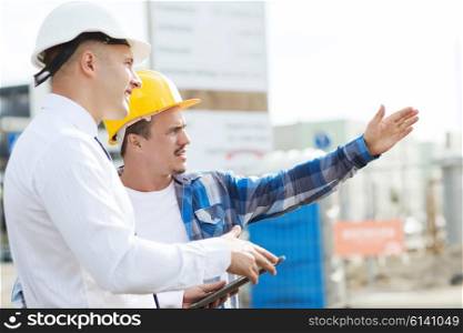 business, building, teamwork, technology and people concept - builder and architect or businessman in hardhats with tablet pc computer outdoors