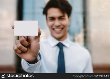 Business Card Mockup Image. Happy Young Businessman Presenting a White Blank Paper Card with Clipping Path