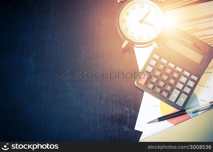 Business chart analysis report with pen, calculator and alarm clock on office table. Business background concept. Soft light and vintage filtered.