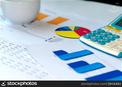 Business chart and Calculator is placed on the table.