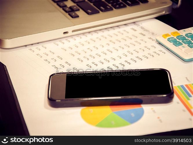 Business chart with smart phone on table.