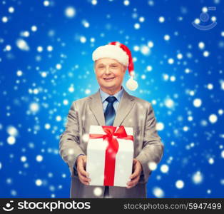 business, christmas, xmas, happiness concept - smiling old man in suit and santa helper hat with gift