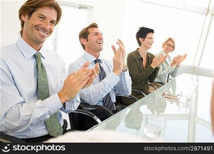 Business colleagues applauding in business meeting