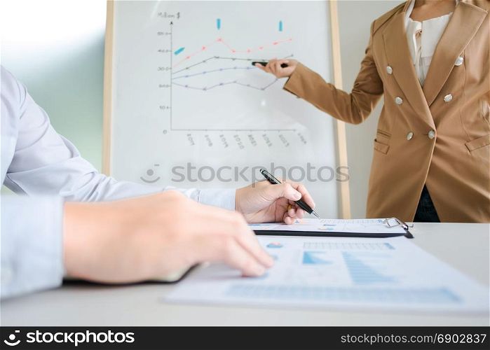 business colleagues brainstorming discussing sales value performance on white board while presentation in modern office room
