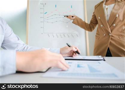 business colleagues brainstorming discussing sales value performance on white board while presentation in modern office room