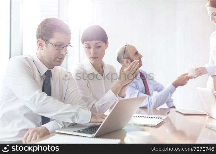 Business colleagues discussing during meeting in boardroom at modern office