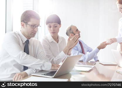 Business colleagues discussing during meeting in boardroom at modern office