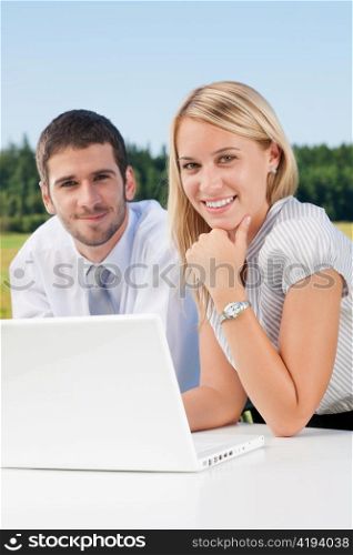 Business colleagues in nature office working on laptop smile