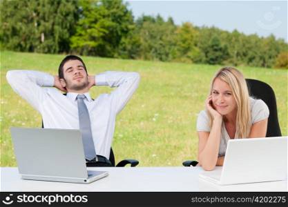 Business colleagues in sunny nature office relax with laptops