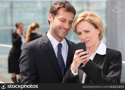 Business colleagues looking at phone